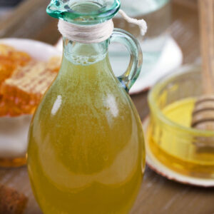 A small glass jar is filled with honey simple syrup.