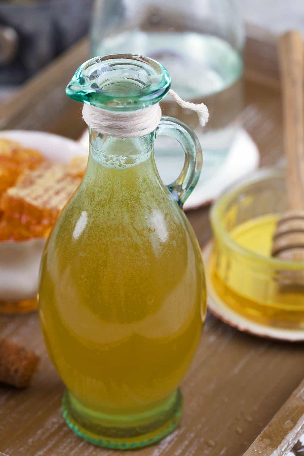 A small glass jar is filled with honey simple syrup. 