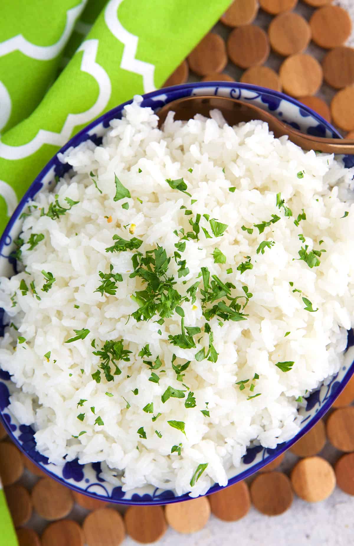 Fresh herbs are placed on top of a bowl of jasmine rice. 