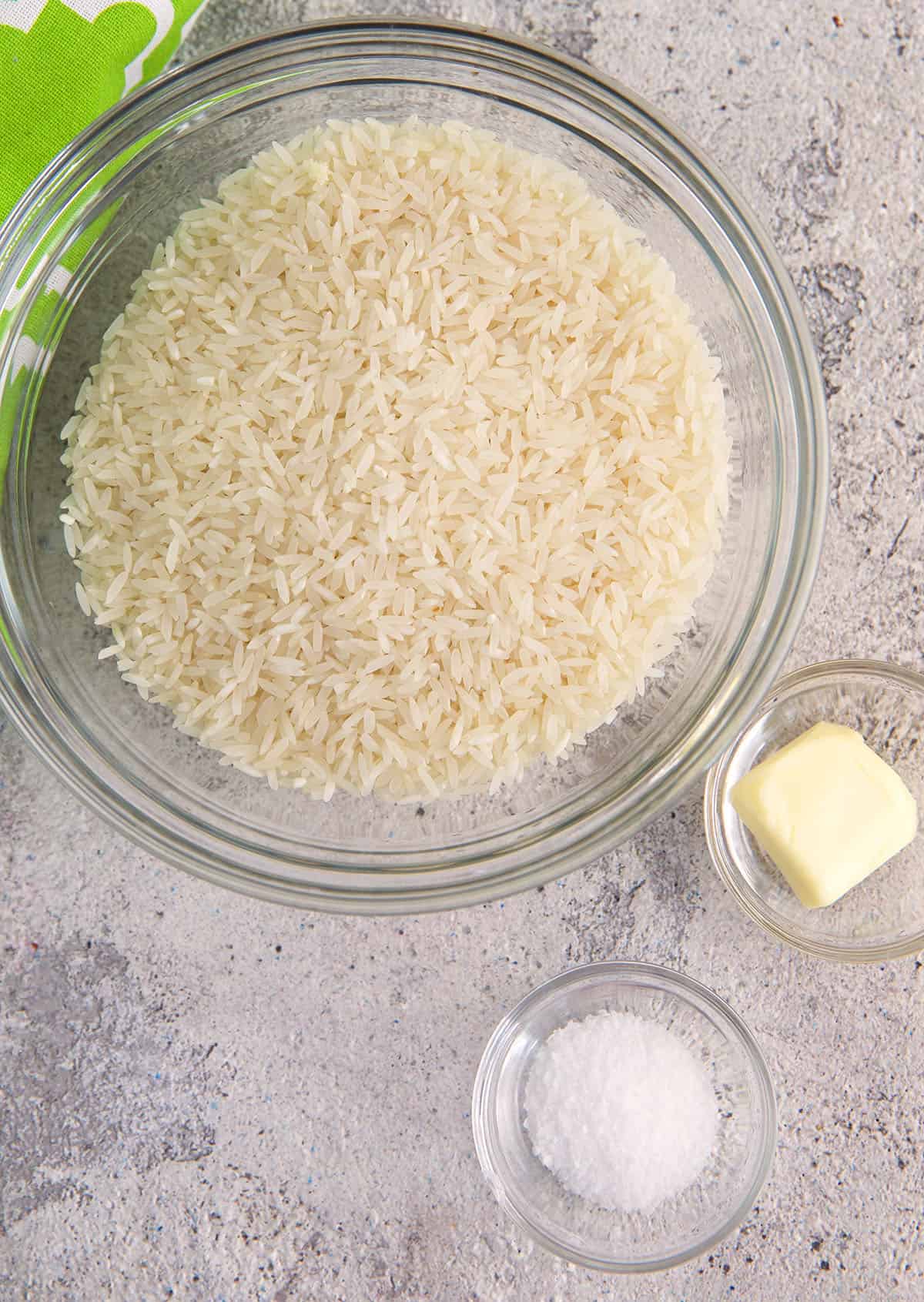 Rice, butter and salt are placed in separate bowls. 