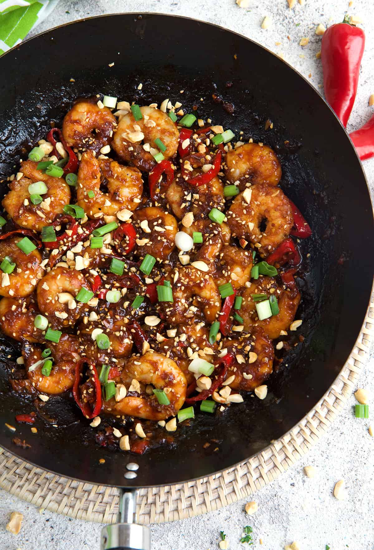 Kung pao shrimp is cooking in a skillet. 
