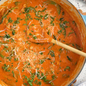 A large dutch oven is filled with tomato florentine soup.