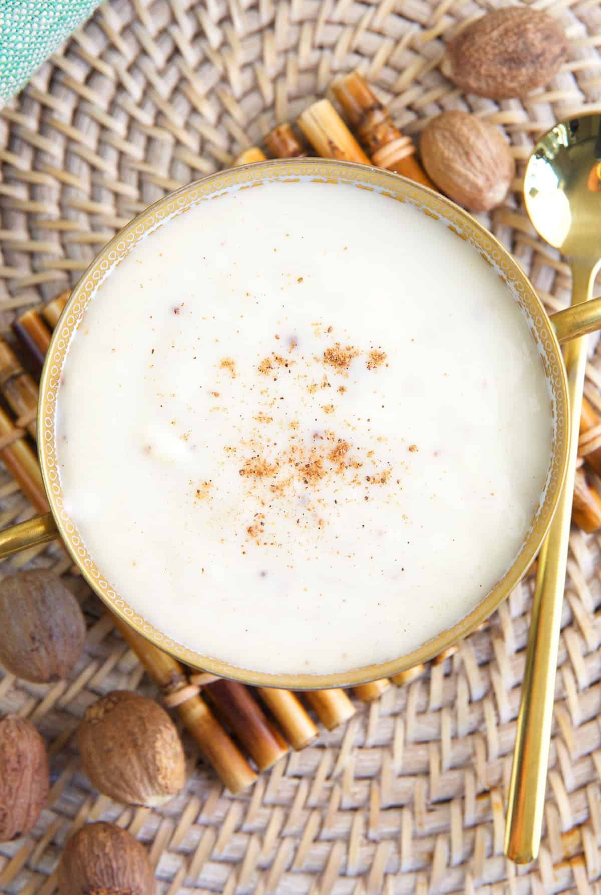 A bowl of bechamel sauce is dusted with nutmeg.