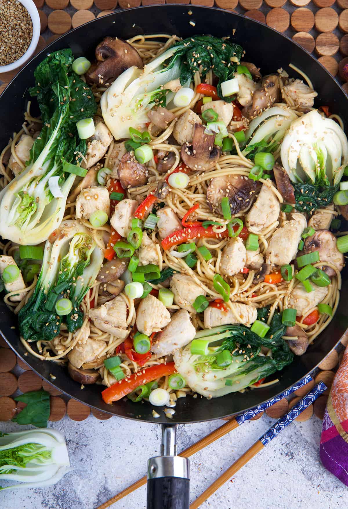 A skillet is filled with chicken chow mein. 