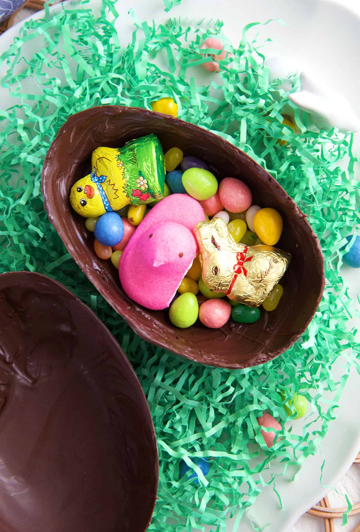 Easter candies are placed in one half of a chocolate egg.