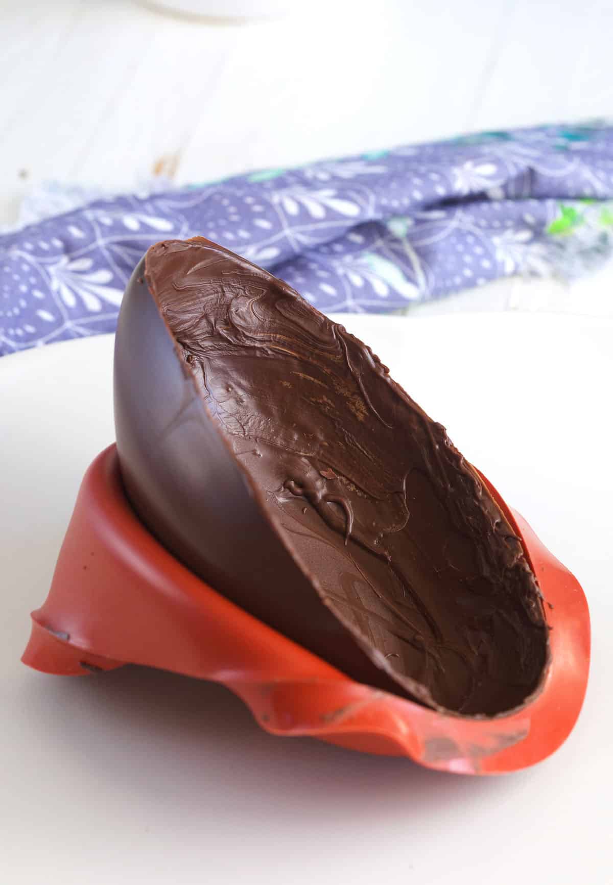 One half of a chocolate egg is placed on a countertop. 