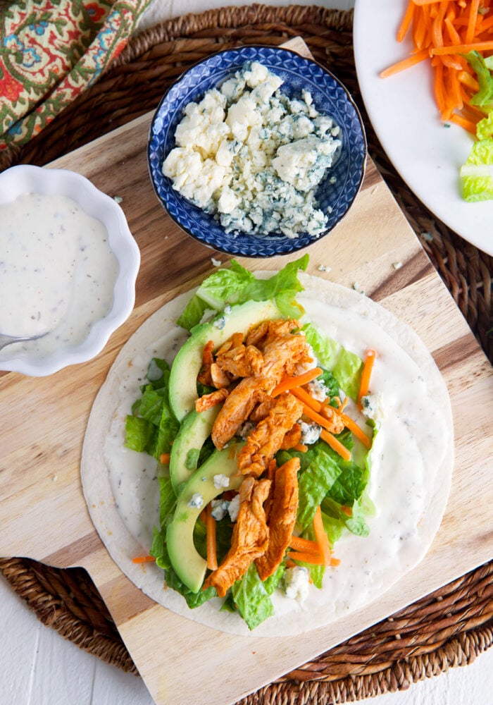 A tortilla is piled with the buffalo chicken wrap ingredients.