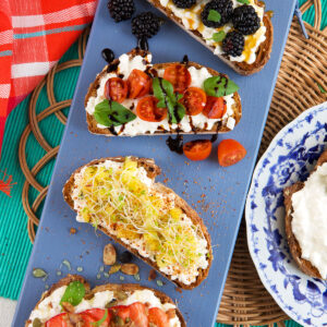 Four pieces of cottage cheese toast are placed on a blue platter.