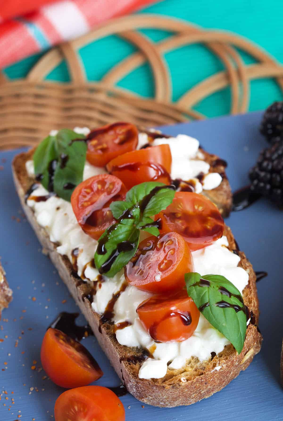 A piece of toast has caprese toppings. 