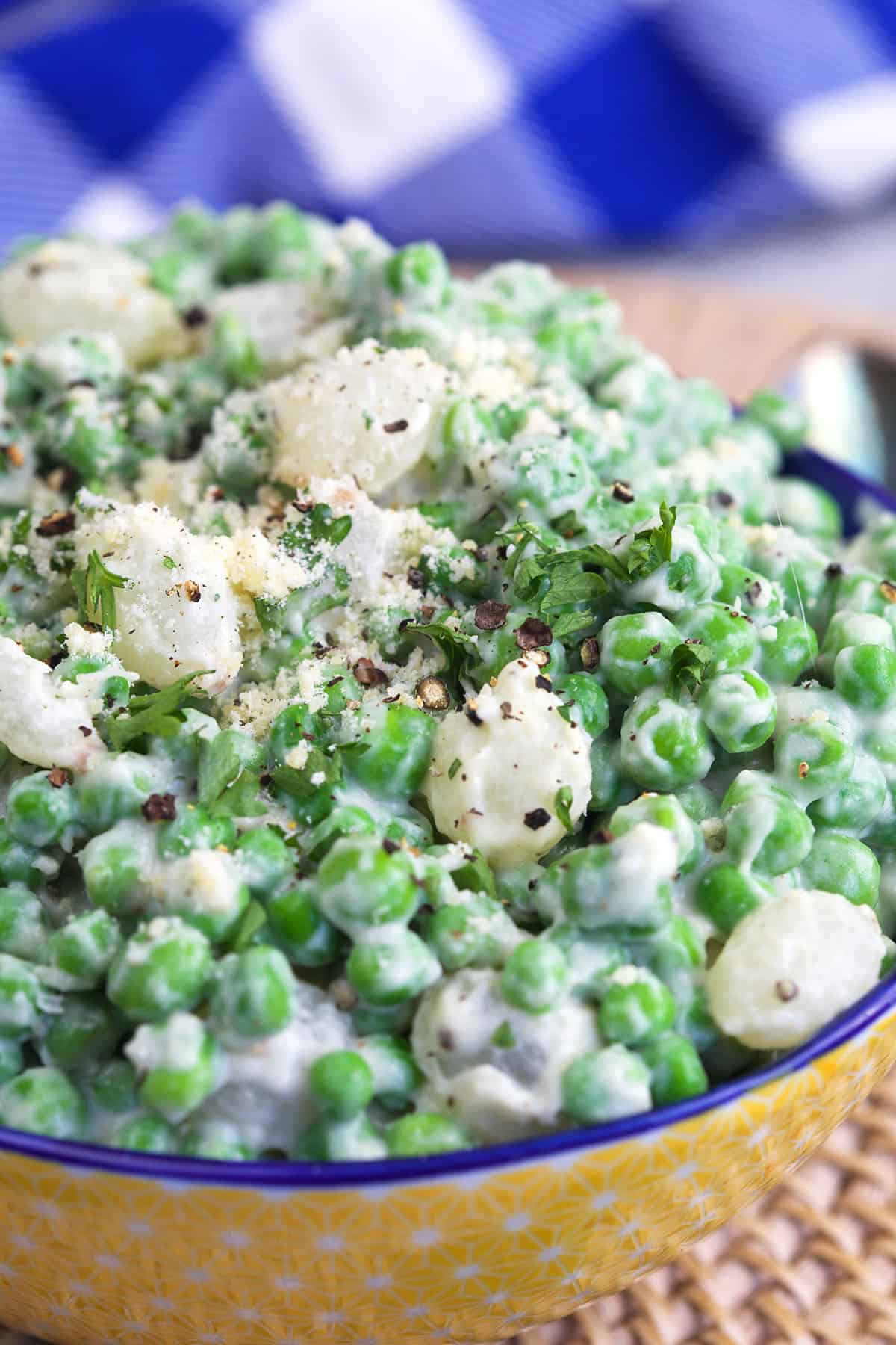 Creamed peas and pearl onions are sprinkled with black pepper. 