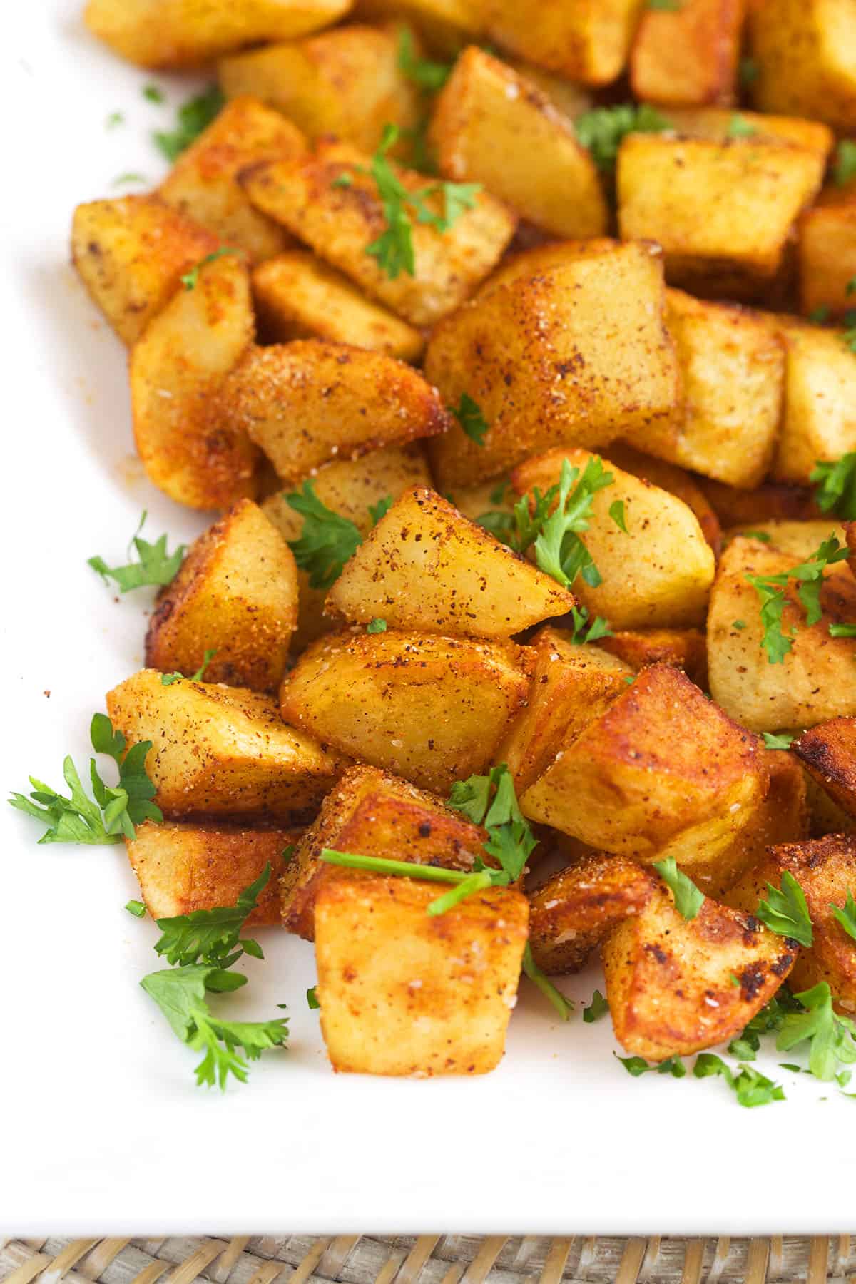 Fresh herbs garnish a platter filled with crispy potatoes. 