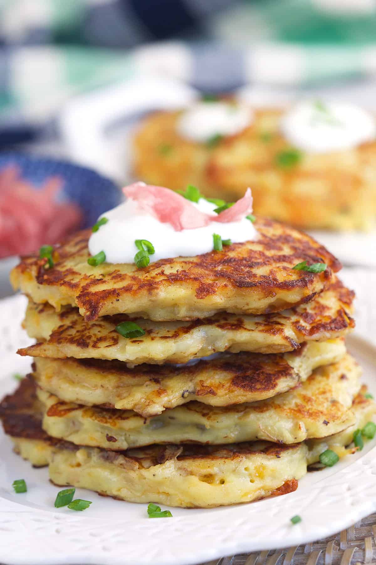 A stack of irish potato pancakes are on a plate. 