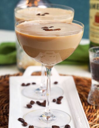 Several espresso martinis are placed on a white platter.