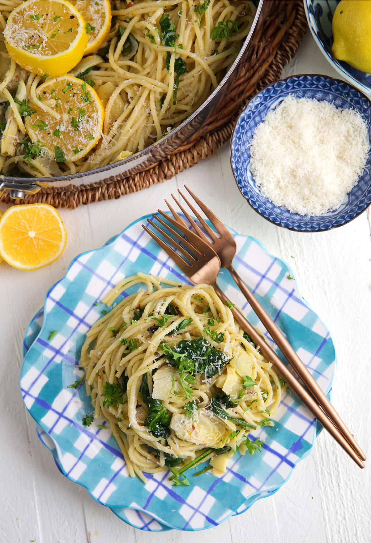 Two forks are plated with a serving of lemon artichoke pasta. 