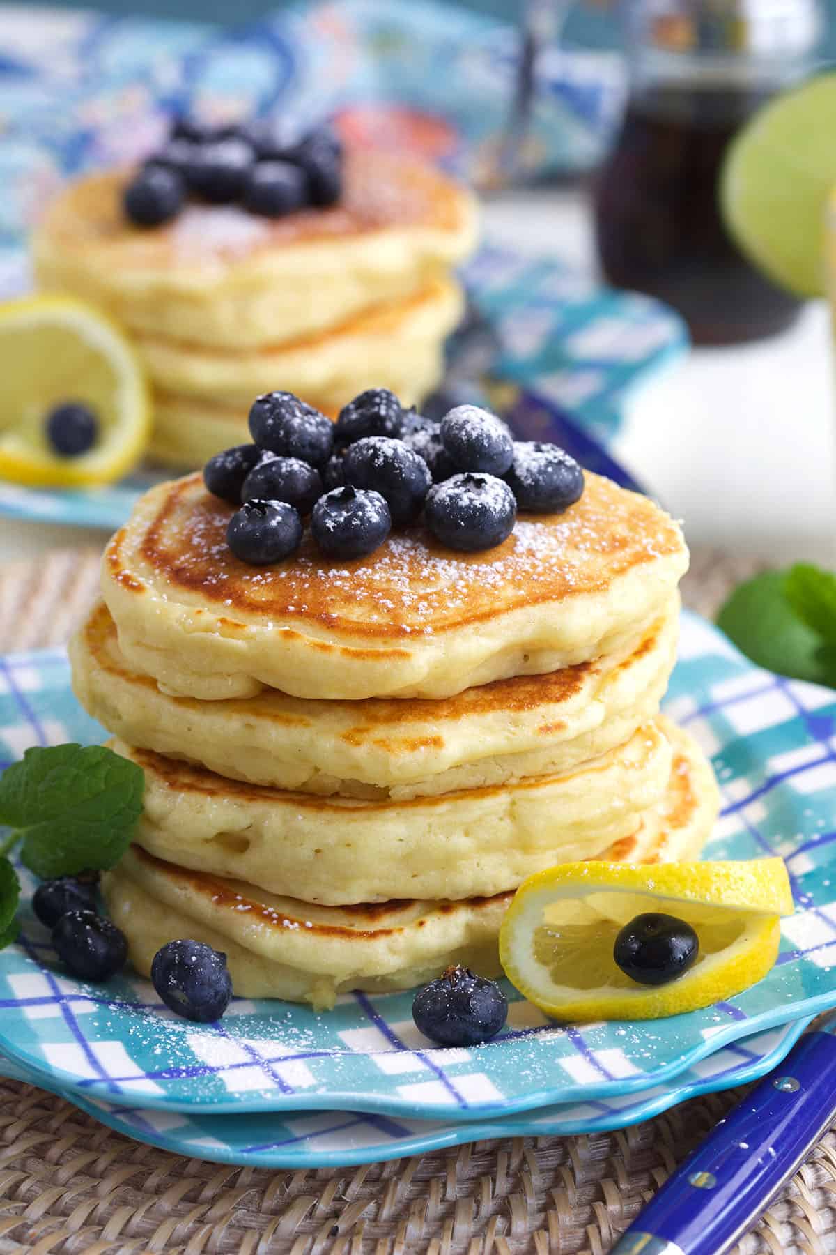 Blueberries and lemon are placed on and around the pancakes. 