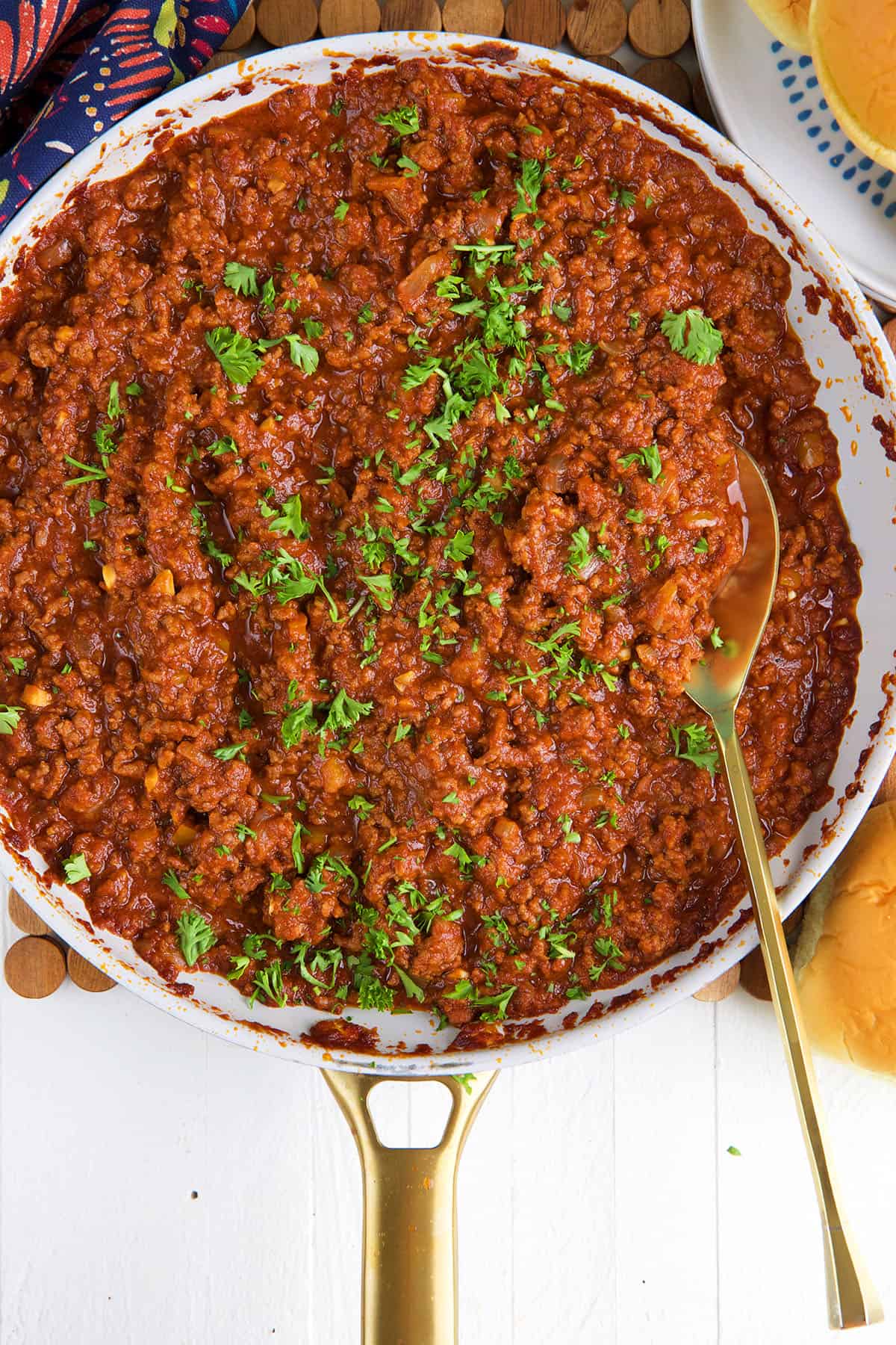 Sloppy Joe Sauce with ground beef in a skillet with a gold serving spoon