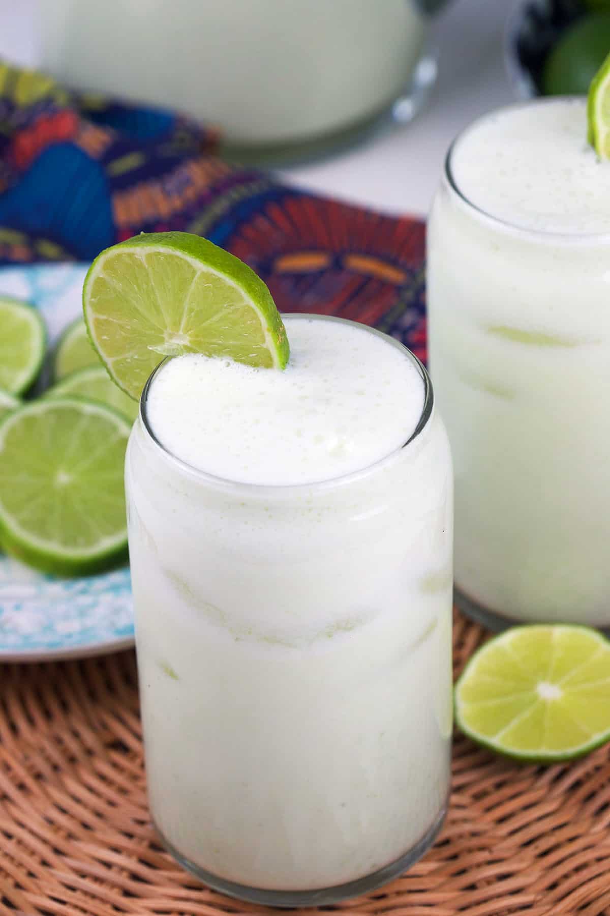 A slice of lime garnishes a glass of lemonade.  