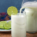 Lemonade is being poured from a pitcher into a glass.