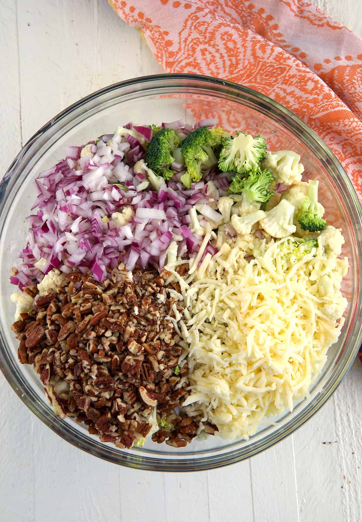 A glass bowl is filled with salad ingredients. 