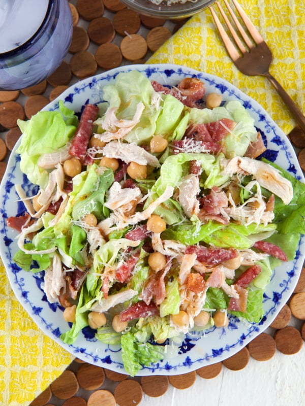 A round plate is topped with salad.