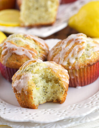 A bite has been taken out of a lemon poppy seed muffin.