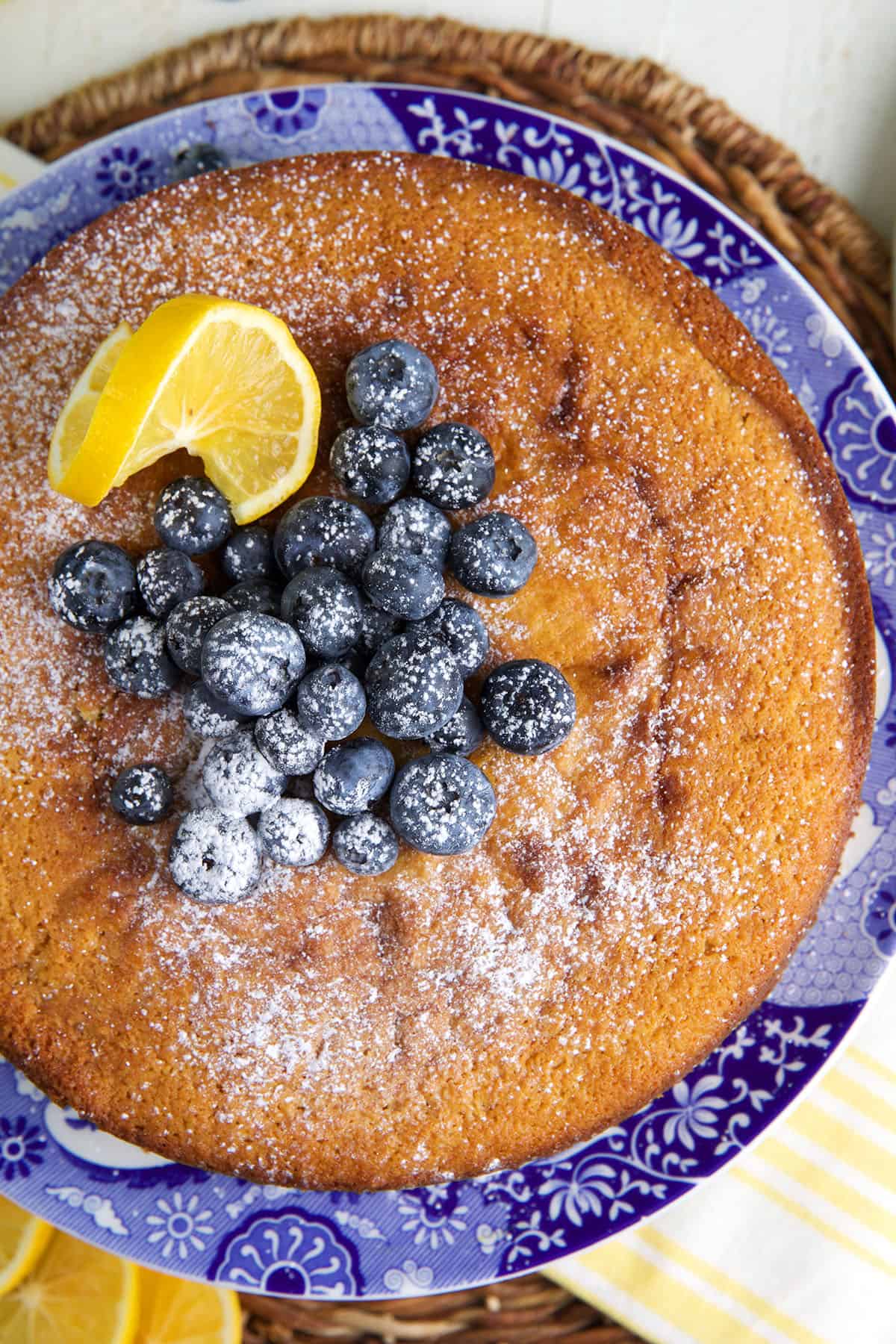Blueberries, lemons and powdered sugar top a lemon ricotta cake.