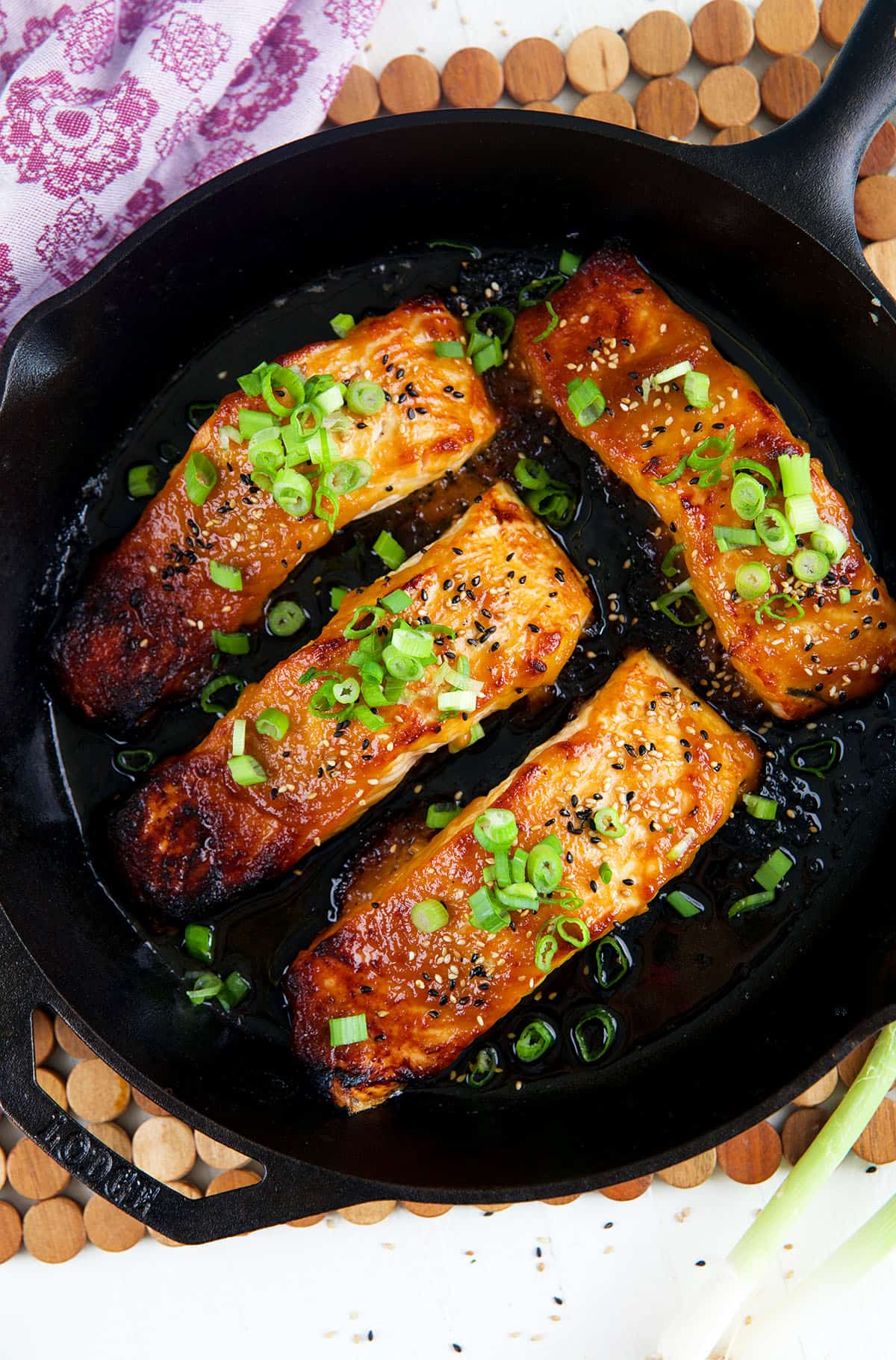 Fully cooked salmon filets are in a skillet. 