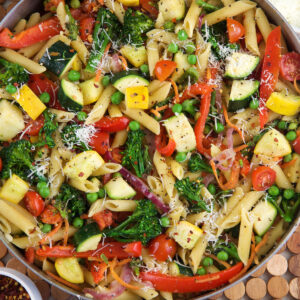Pasta Primavera in a large skillet on a wood placemat.
