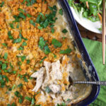 A serving spoon is placed in a poppy seed chicken casserole dish.