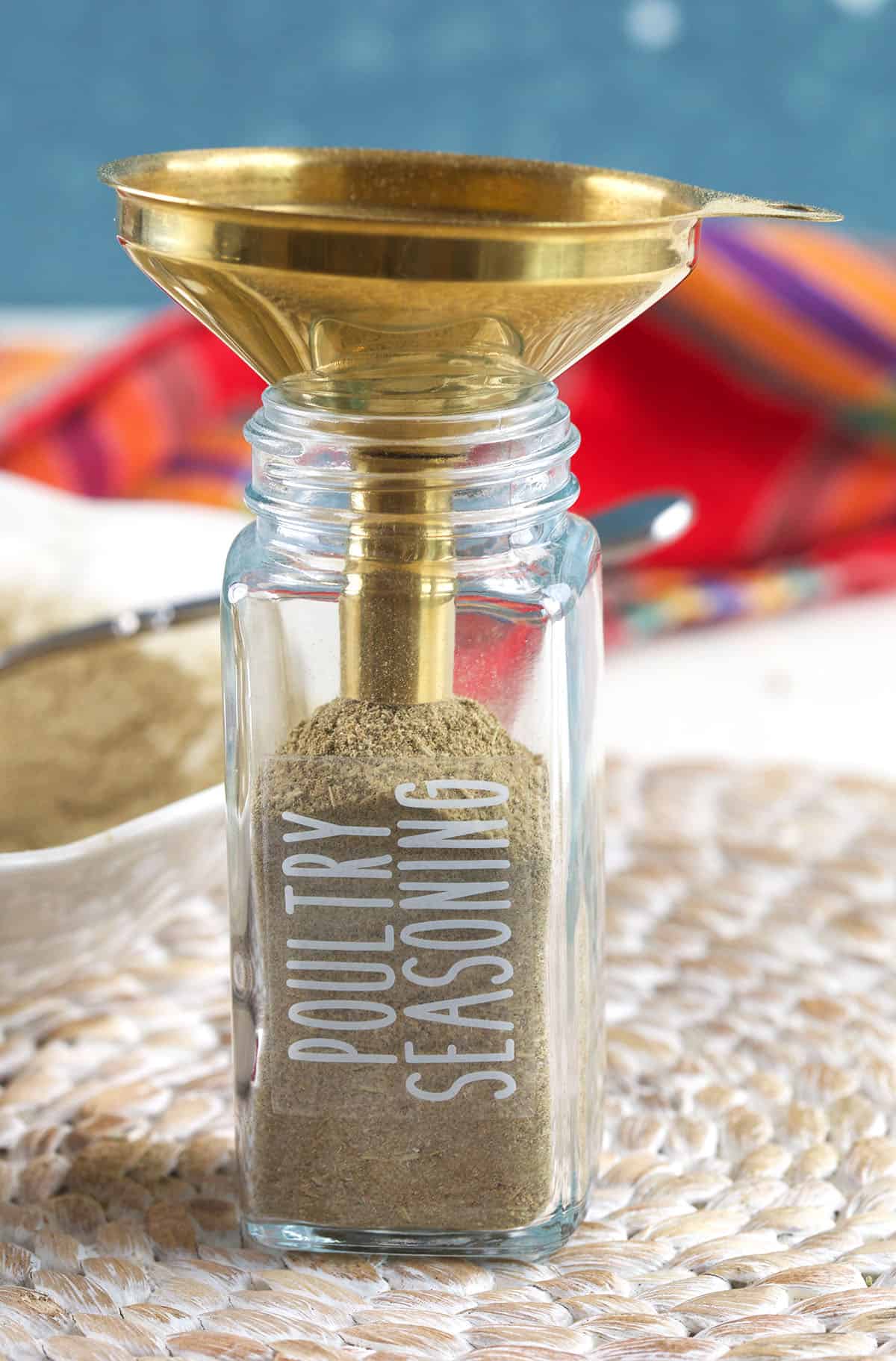 A small funnel is placed on top of a spice jar. 