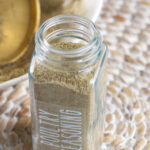 A glass jar is filled with poultry seasoning.