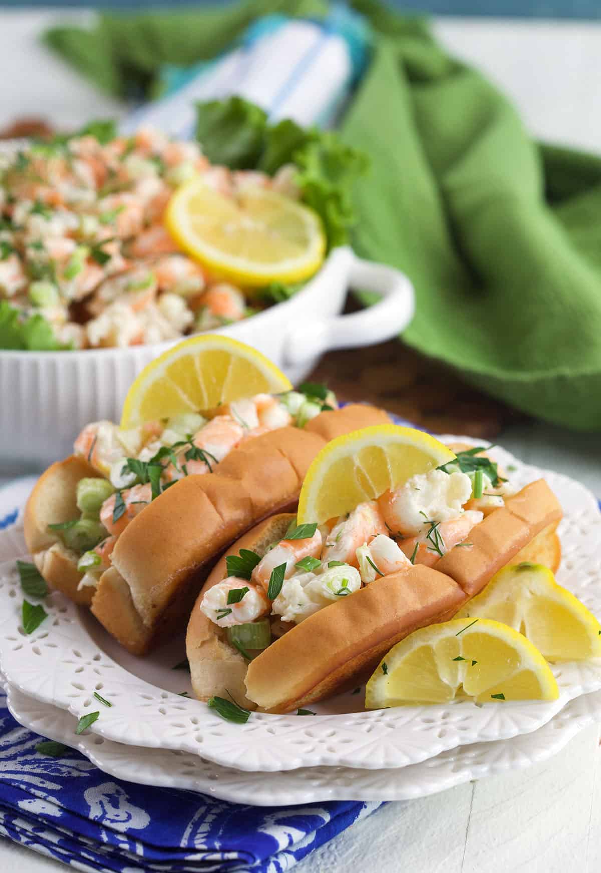 Lemon wedges are placed on the same plate with shrimp salad. 