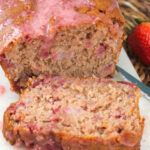 A slice of strawberry bread has been cut from the whole loaf.