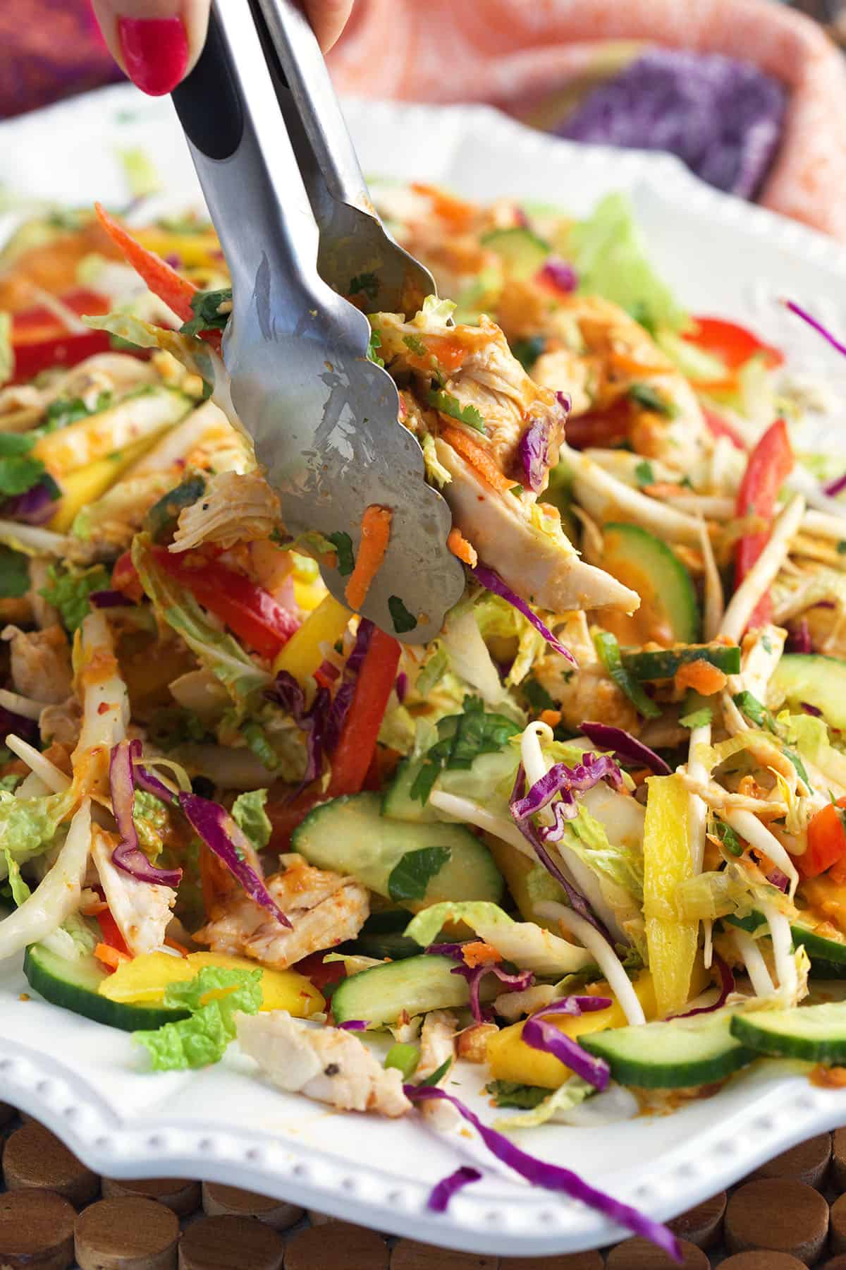Thai Chicken Salad being served with tongs.