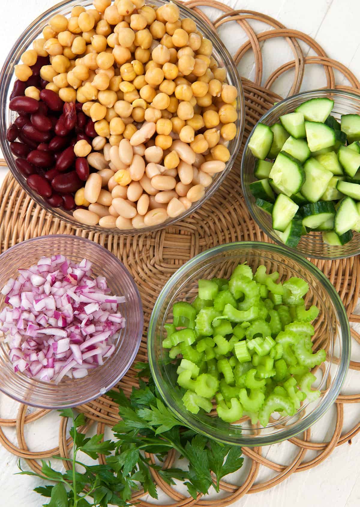 Ingredients for three bean salad are spread on a place mat. 