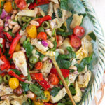 A large serving spoon is placed in a bowl of salad.