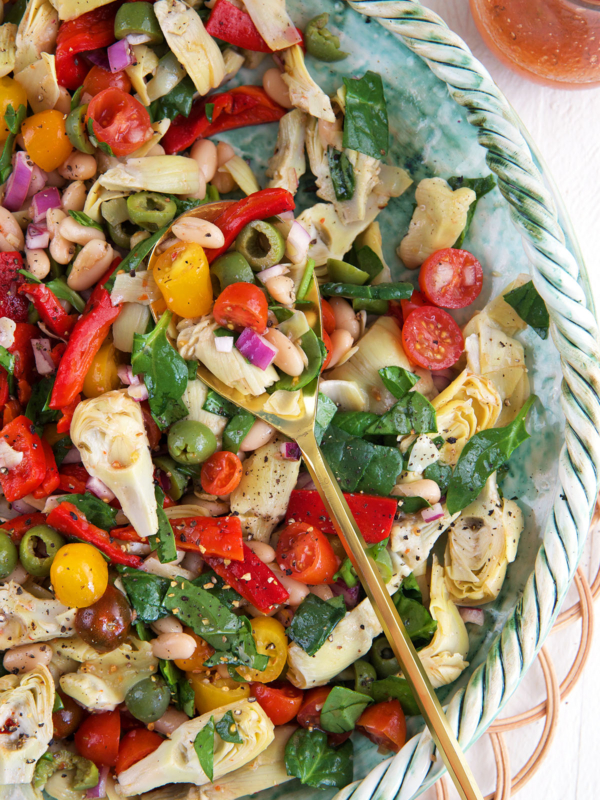 A large serving spoon is placed in a bowl of salad.