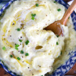 Mashed potatoes being served with a wooden spoon.