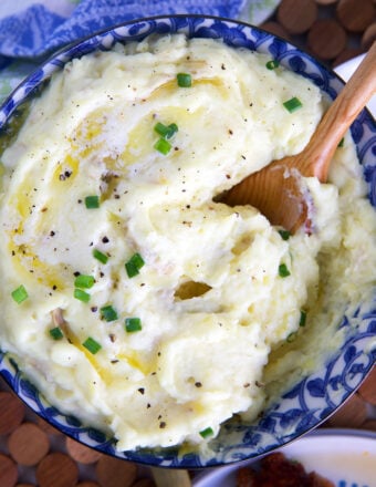 Mashed potatoes being served with a wooden spoon.