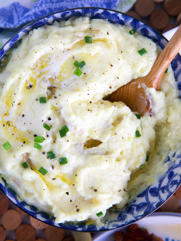 Mashed potatoes being served with a wooden spoon.