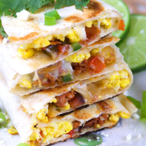 A stack of breakfast quesadillas are on a plate.