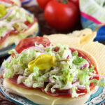 A sandwich is plated with potato chips.