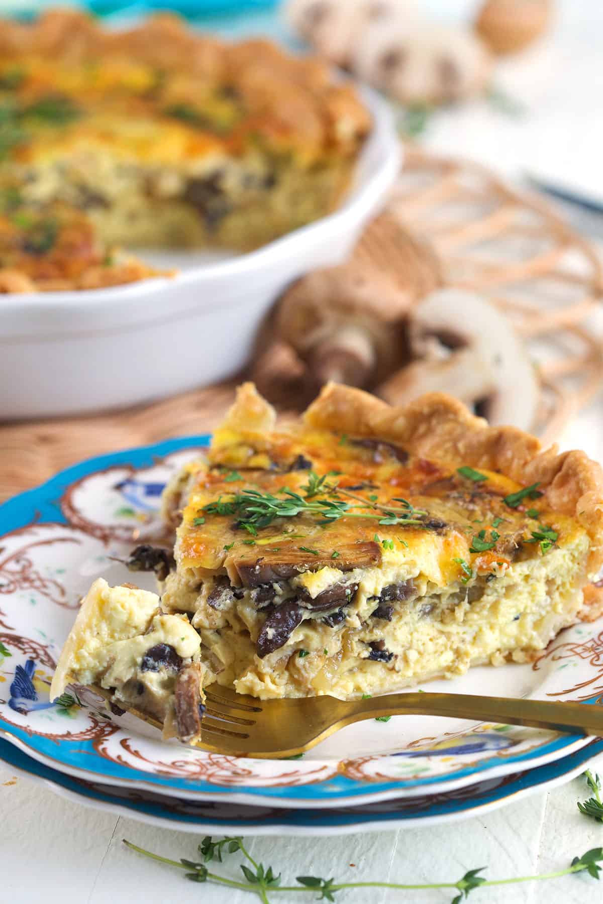 A fork has removed a bite of mushroom quiche. 