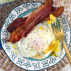 Bacon and eggs are on a plate.