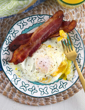 Bacon and eggs are on a plate.