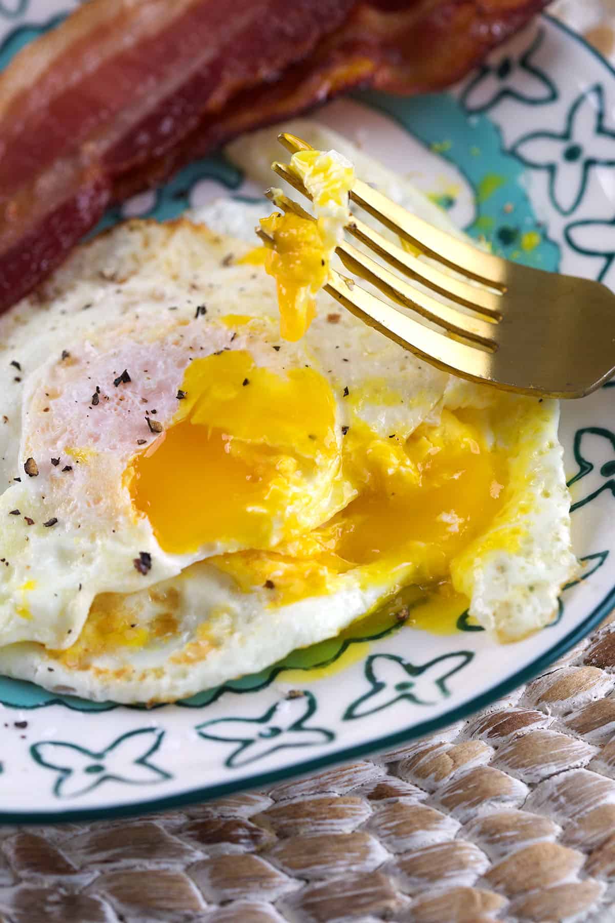 A fork has pierced a cooked egg. 