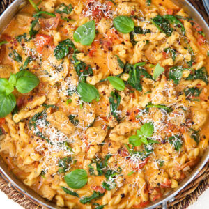 A skillet is filled with tuscan chicken pasta.