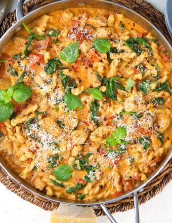 A skillet is filled with tuscan chicken pasta.