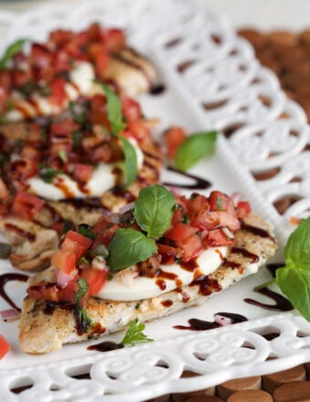 Several servings of bruschetta chicken are on a white plate.