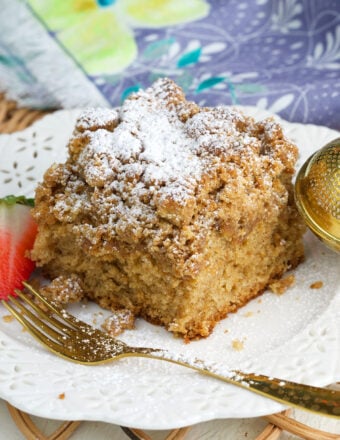 Powdered sugar is sprinkled across a single piece of crumb cake.